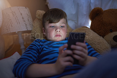 Buy stock photo Home, lying and child on smartphone in bed for game, relax and streaming cartoon or movies in bedroom. Young boy, connection and tech in house for learning, education or reading ebook on app online
