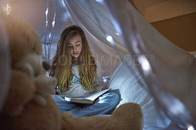 Buy stock photo Night, girl and blanket fort for reading book, learning or education for childhood development. Home, child and fairytale with storytelling, relax or fantasy for entertainment or knowledge in house