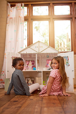 Buy stock photo Portrait of two friends playing together with a dollhouse