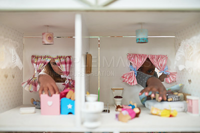 Buy stock photo Cropped shot of two friends playing together with a dollhouse