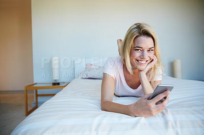 Buy stock photo Shot of a young woman using her cellphone while relaxing in her bedroom
