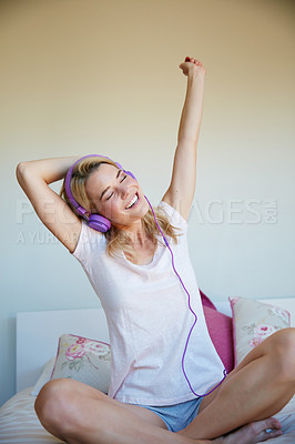 Buy stock photo Shot of an attractive young woman listening to music in her bedroom