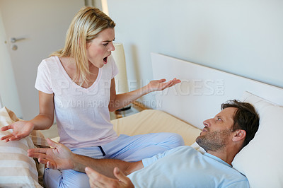 Buy stock photo Shot of a young couple having an argument in bed