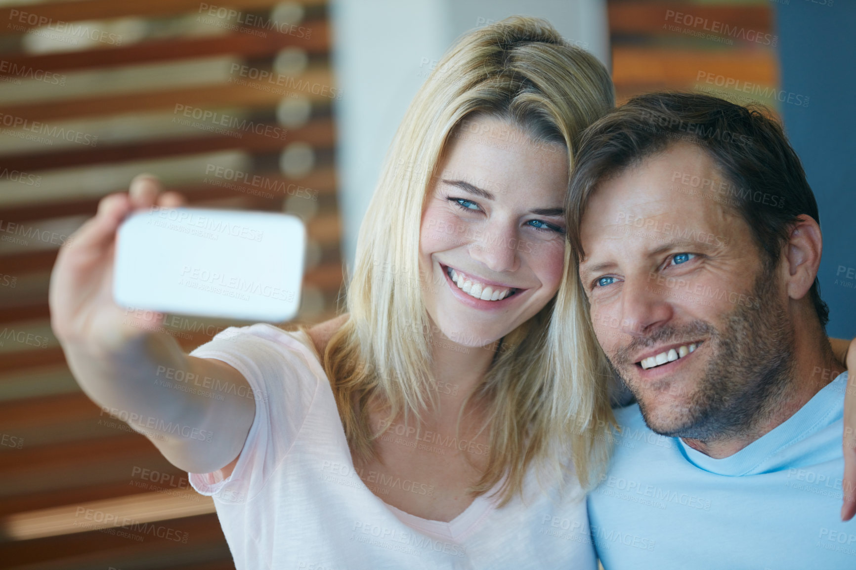 Buy stock photo Shot of a young couple taking a selfie at home