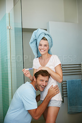 Buy stock photo Shot of a young couple looking happy after taking a pregnancy test in the bathroom