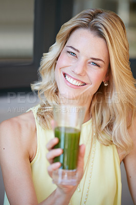 Buy stock photo Portrait of a happy young woman enjoying a healthy smoothie at home