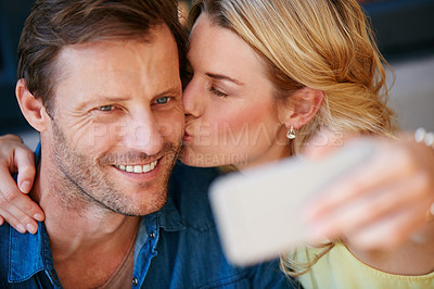 Buy stock photo Shot of a happy couple taking a selfie together on a phone