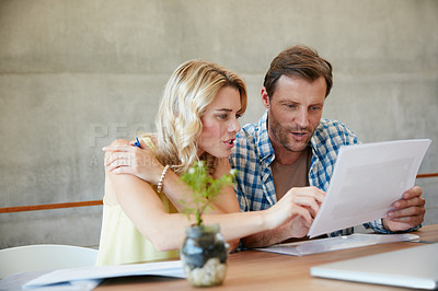 Buy stock photo Shot of a couple going through their paperwork together at home