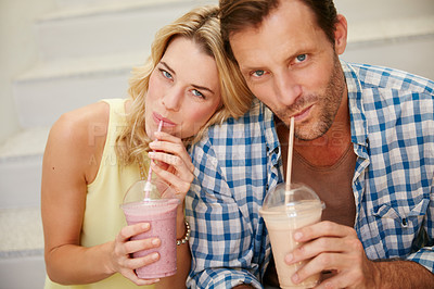 Buy stock photo Shot of a happy couple enjoying refreshing shakes together