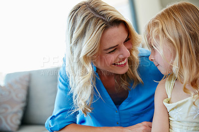 Buy stock photo Shot of a young mother talking to her daughter while sitting on the sofa at home