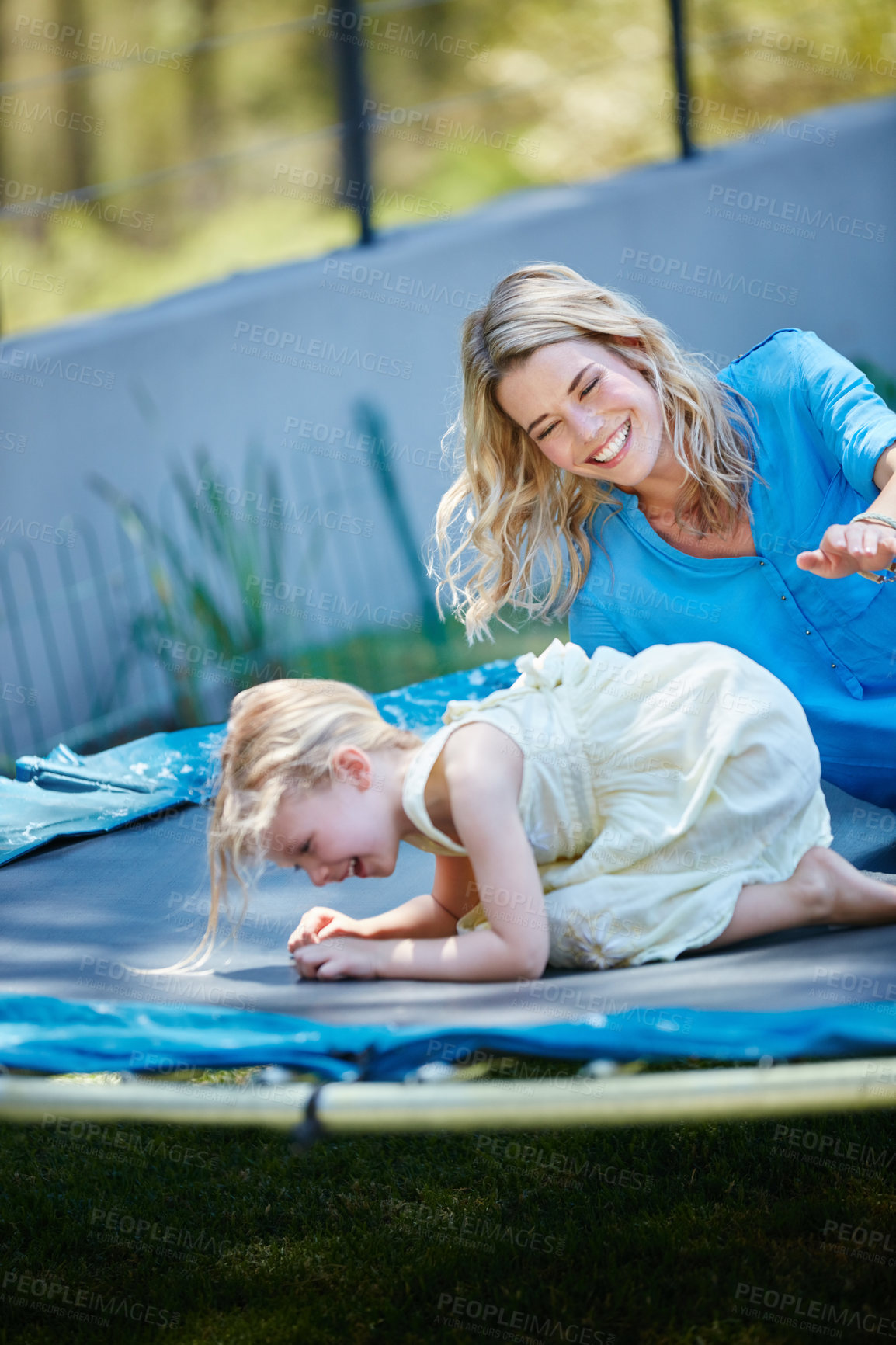 Buy stock photo Shot of a young mother playing on the trampoline with her daughter outside