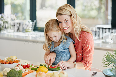 Buy stock photo Cropped shot of a mother and daughter preparing a meal together at home