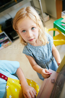 Buy stock photo Cropped shot of a little girl writing on a chalkboard at home
