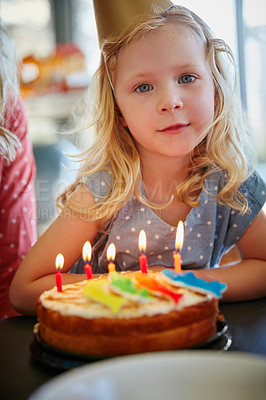 Buy stock photo Portrait of an adorable little girl sitting in front of her birthday cake