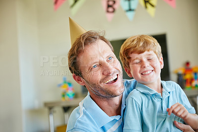 Buy stock photo Cropped shot of a father and son having a birthday party at home