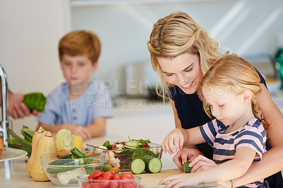 Buy stock photo Cropped shot of a mother cooking together with her two kids at home