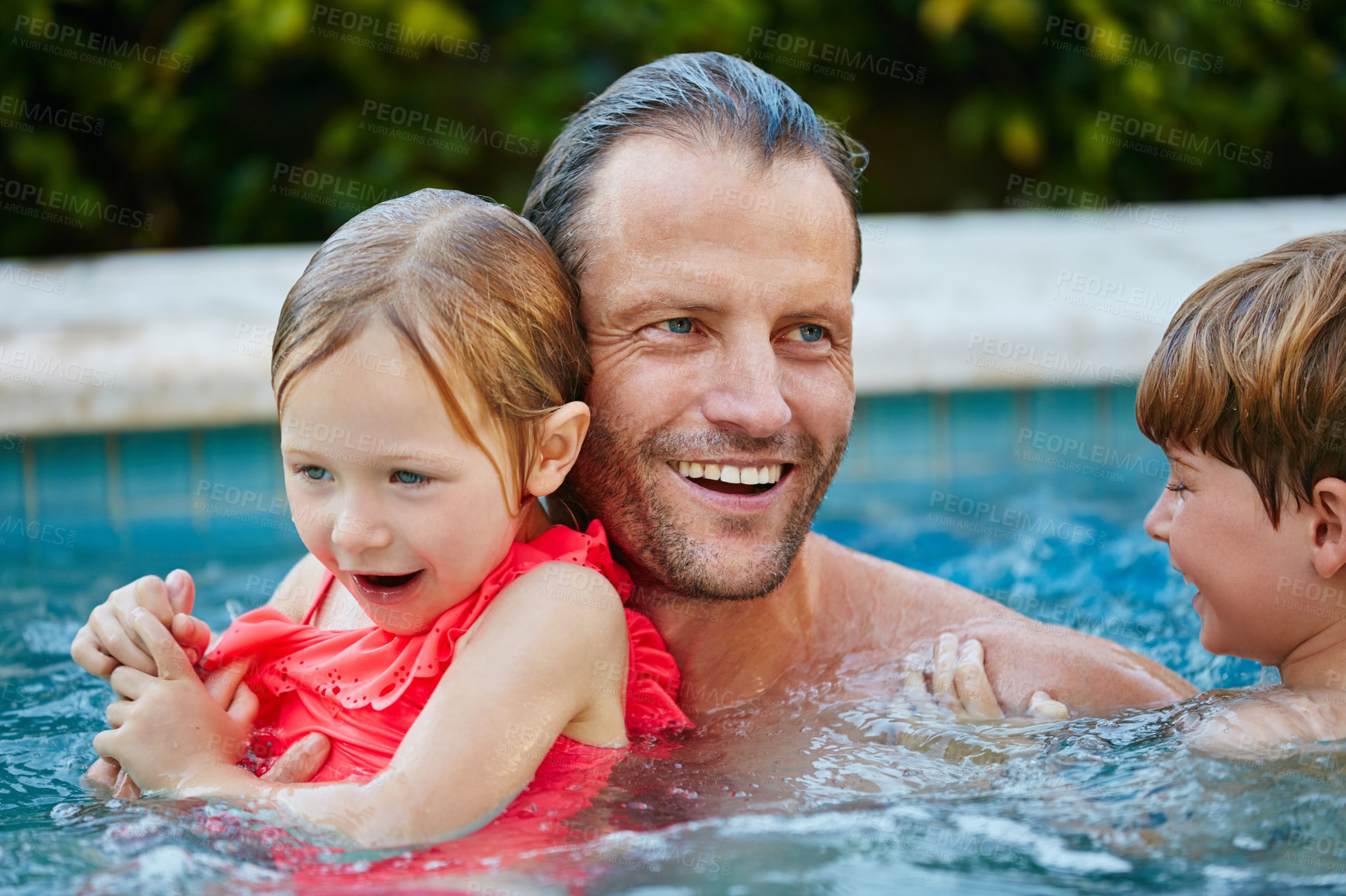 Buy stock photo Cropped shot of a father swimming in a pool with his son and daughter