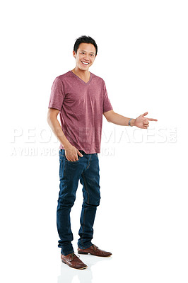 Buy stock photo Studio portrait of a young man pointing at blank copyspace while standing against a white background