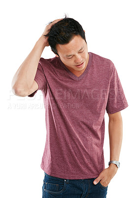 Buy stock photo Studio shot of a young man holding his sore head against a white background