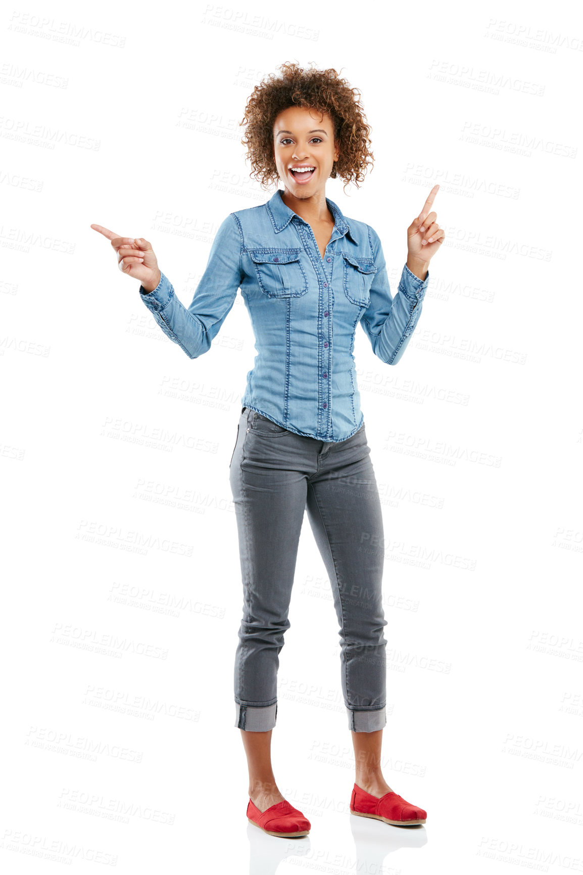 Buy stock photo Studio shot of an attractive young woman pointing in two different directions