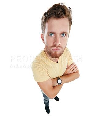 Buy stock photo Studio portrait of an angry young man standing with his arms folded against a white background