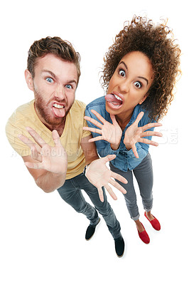 Buy stock photo Studio portrait of a young couple pulling faces at the camera against a white background