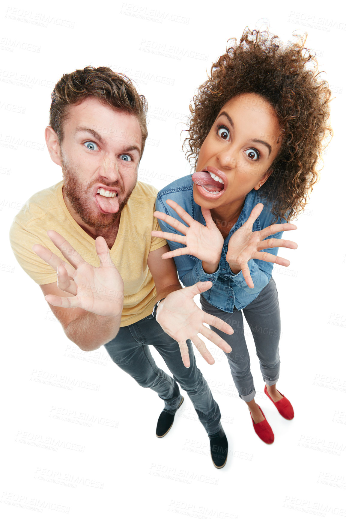Buy stock photo Studio portrait of a young couple pulling faces at the camera against a white background