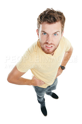 Buy stock photo Studio portrait of an angry young man standing with his hands on his hips against a white background