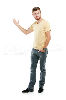 Buy stock photo Studio portrait of a young man pointing at blank copyspace while standing against a white background