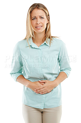 Buy stock photo Shot of an unhappy woman holding her sore stomach against a white background