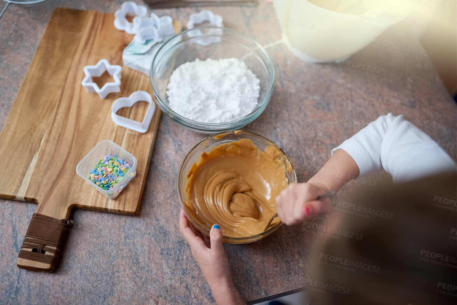 Buy stock photo Girl, hands and baking with bowl of dessert on table for cupcake mixture, caramel or topping above at home. Top view of little child or baker mixing sweet ingredients for cookies or delicious treat