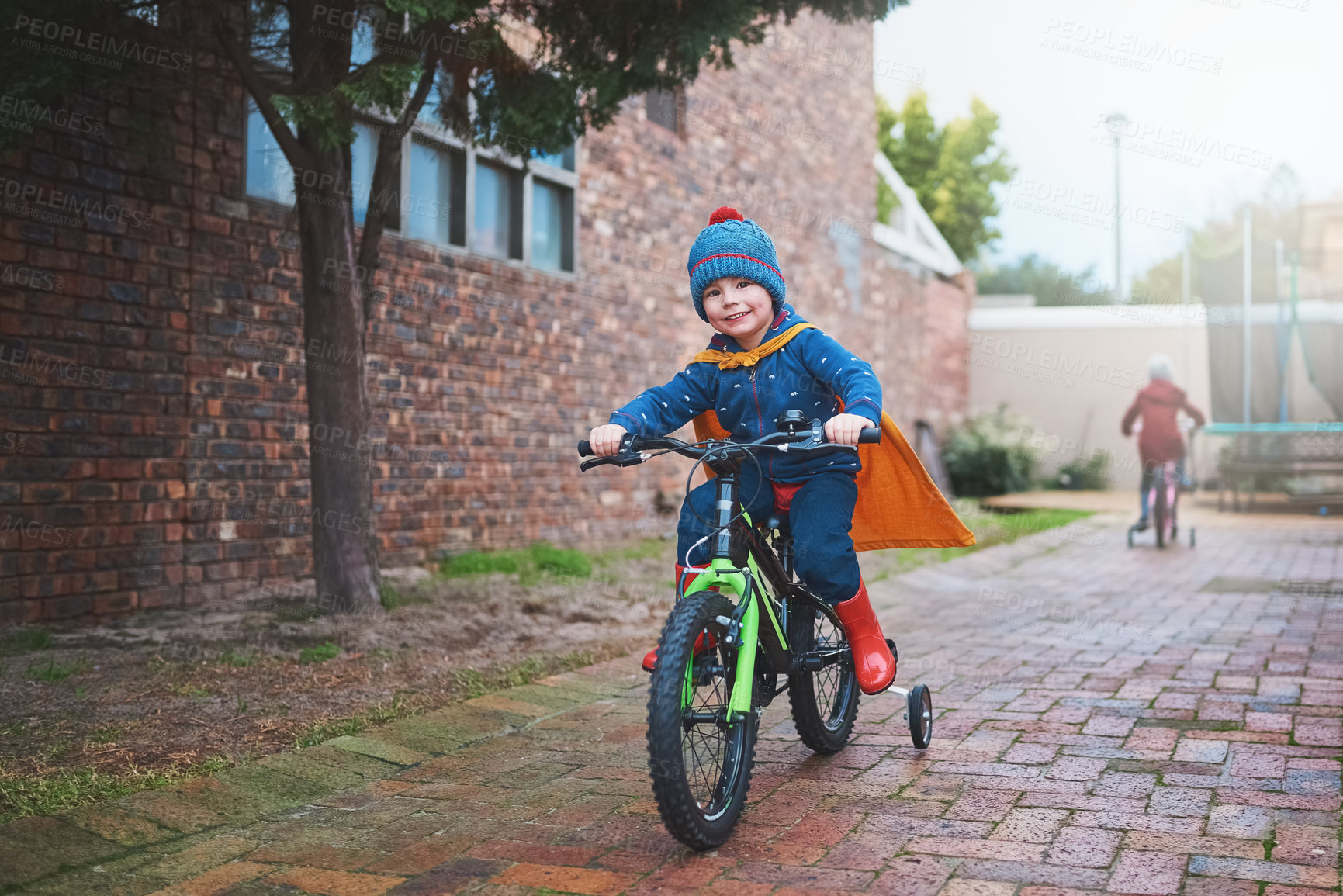 Buy stock photo Portrait of a little boy riding on a bicycle outside