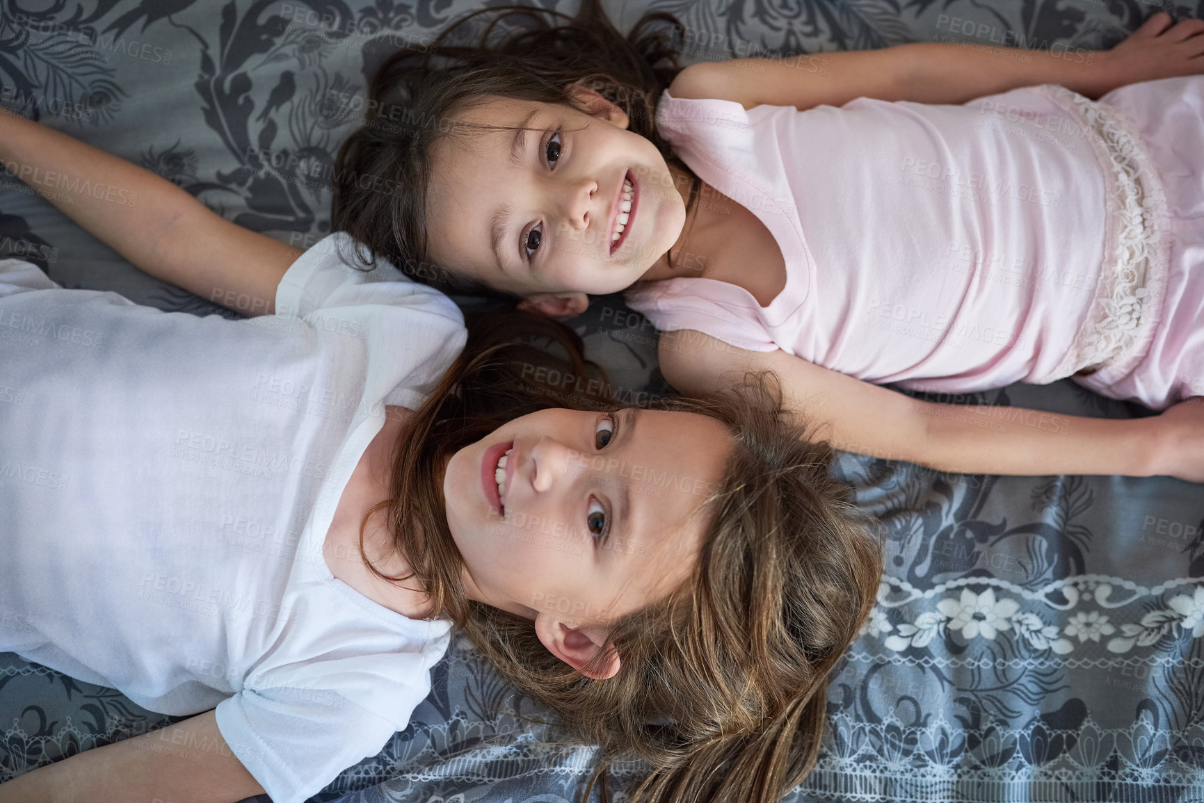 Buy stock photo Children, portrait and top view on bed as sisters with childhood bonding, connection or happiness. Kids, friends and face with youth smile in home from above for family love, relaxing or together