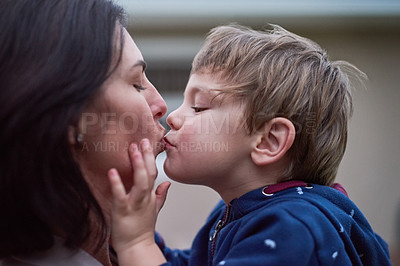 Buy stock photo Cropped shot of a little boy kissing his mother