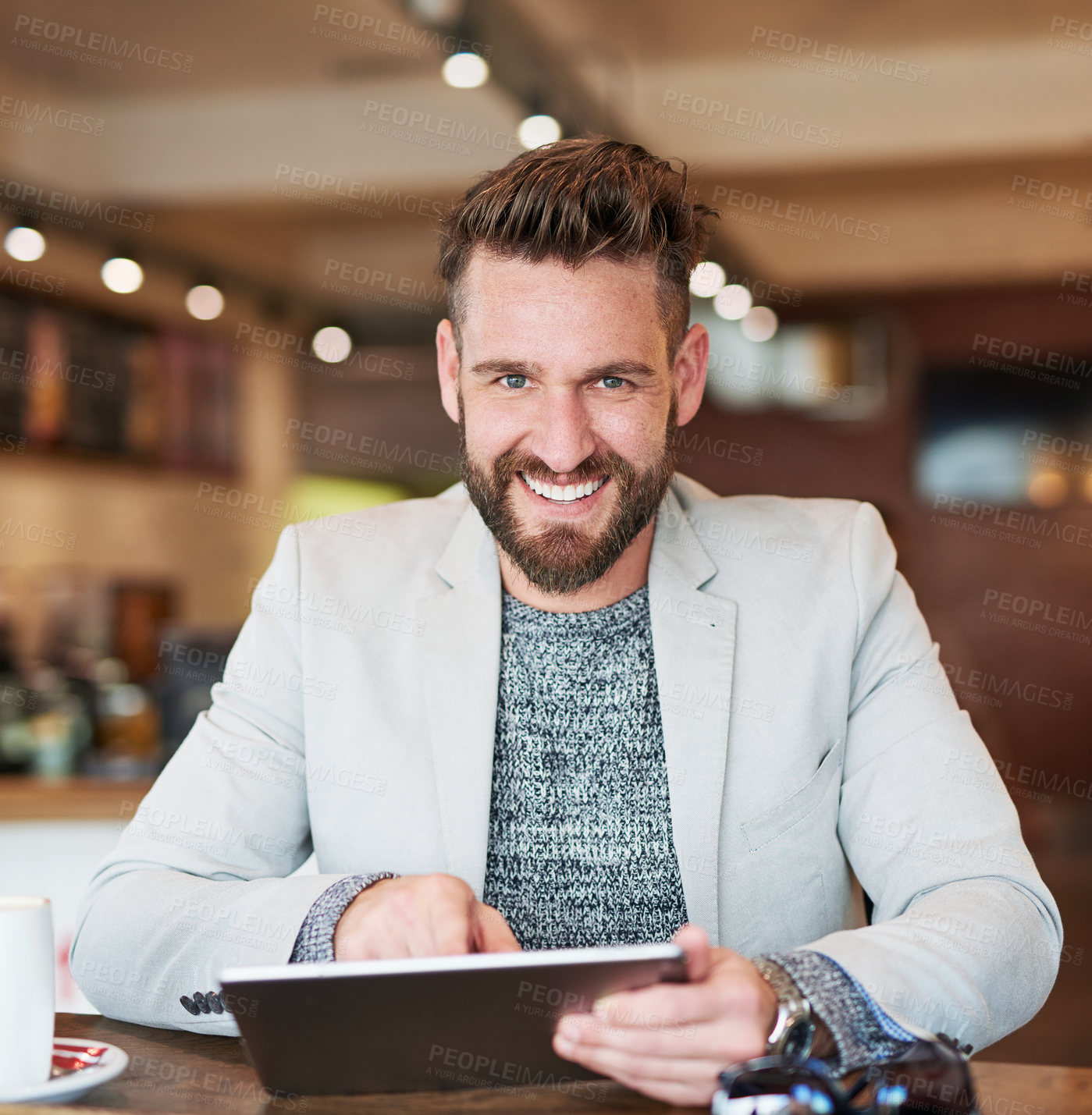 Buy stock photo Cropped portrait of a modern businessman using his digital tablet in a coffee shop