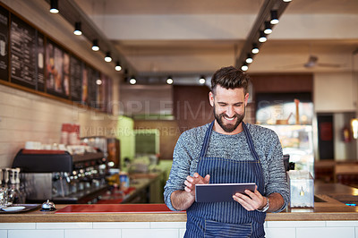 Buy stock photo Cropped shot of a business owner using a digital tablet in his cafe