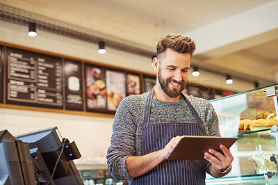 Buy stock photo Cropped shot of a business owner using a digital tablet in his cafe