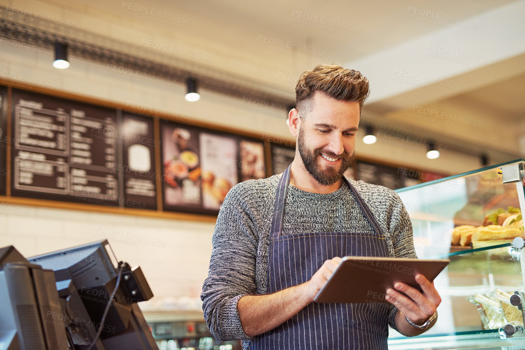 Buy stock photo Cropped shot of a business owner using a digital tablet in his cafe