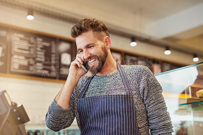 Buy stock photo Cropped shot of a business owner talking on a cellphone in his cafe