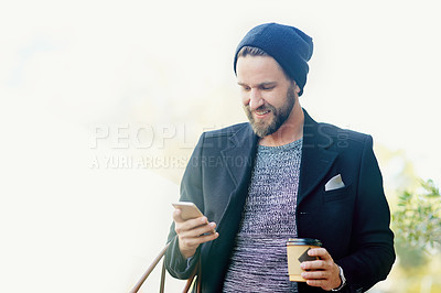 Buy stock photo Cropped shot of a young man texting on his cellphone outside