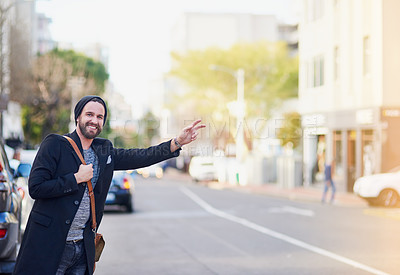 Buy stock photo Cropped shot of a young man gesturing to get a cab in the city