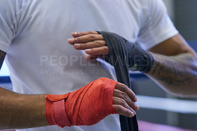 Buy stock photo Shot of an unrecognizable man strapping his hands and wrists in he boxing gym