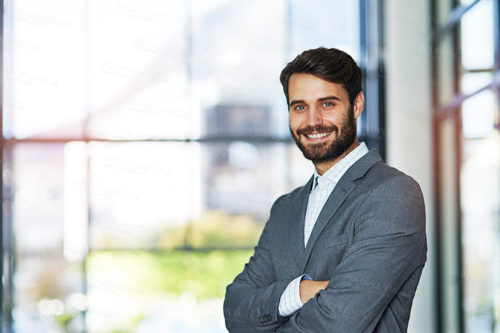 Buy stock photo Portrait of a confident young businessman standing in a modern office