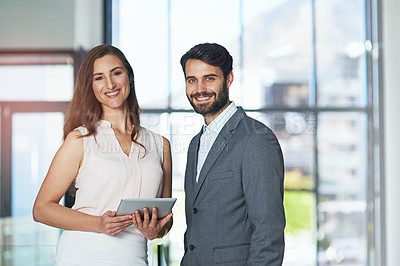 Buy stock photo Portrait of a young businessman and businesswoman using a digital tablet together in an office