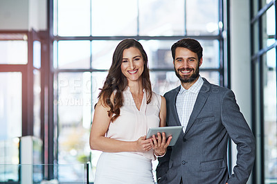 Buy stock photo Portrait of a young businessman and businesswoman using a digital tablet together in an office