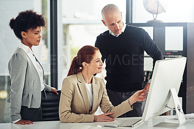 Buy stock photo Shot of a group of businesspeople working on a computer together while working in an office