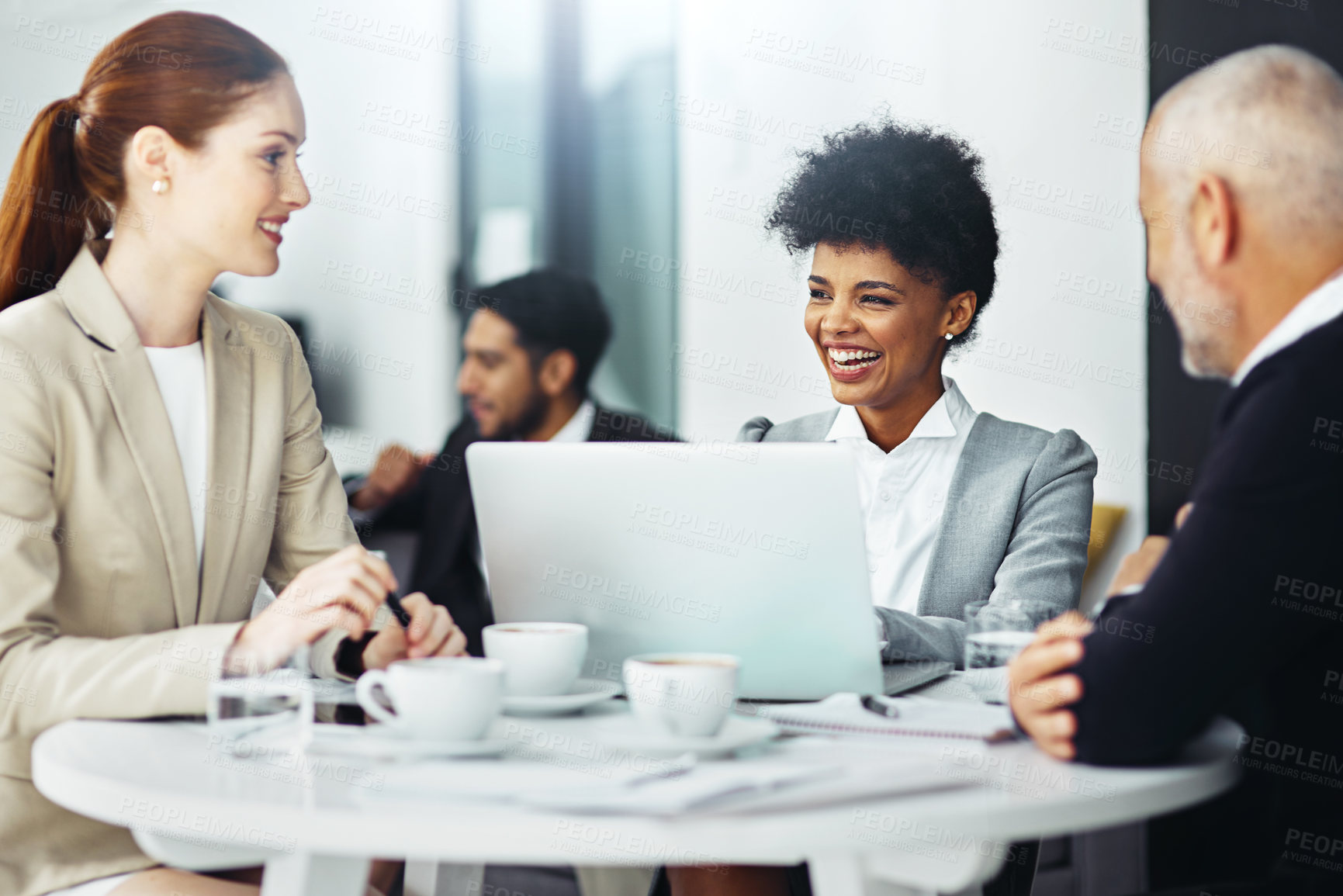 Buy stock photo Shot of a group of businesspeople working on a laptop together while sitting at a table in an office