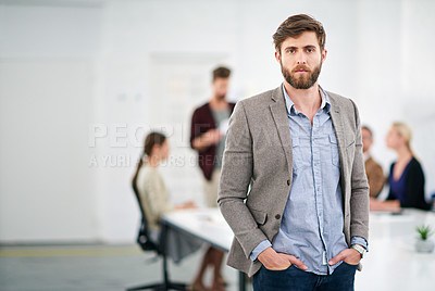 Buy stock photo Portrait of a young businessman in an office with colleagues in the background