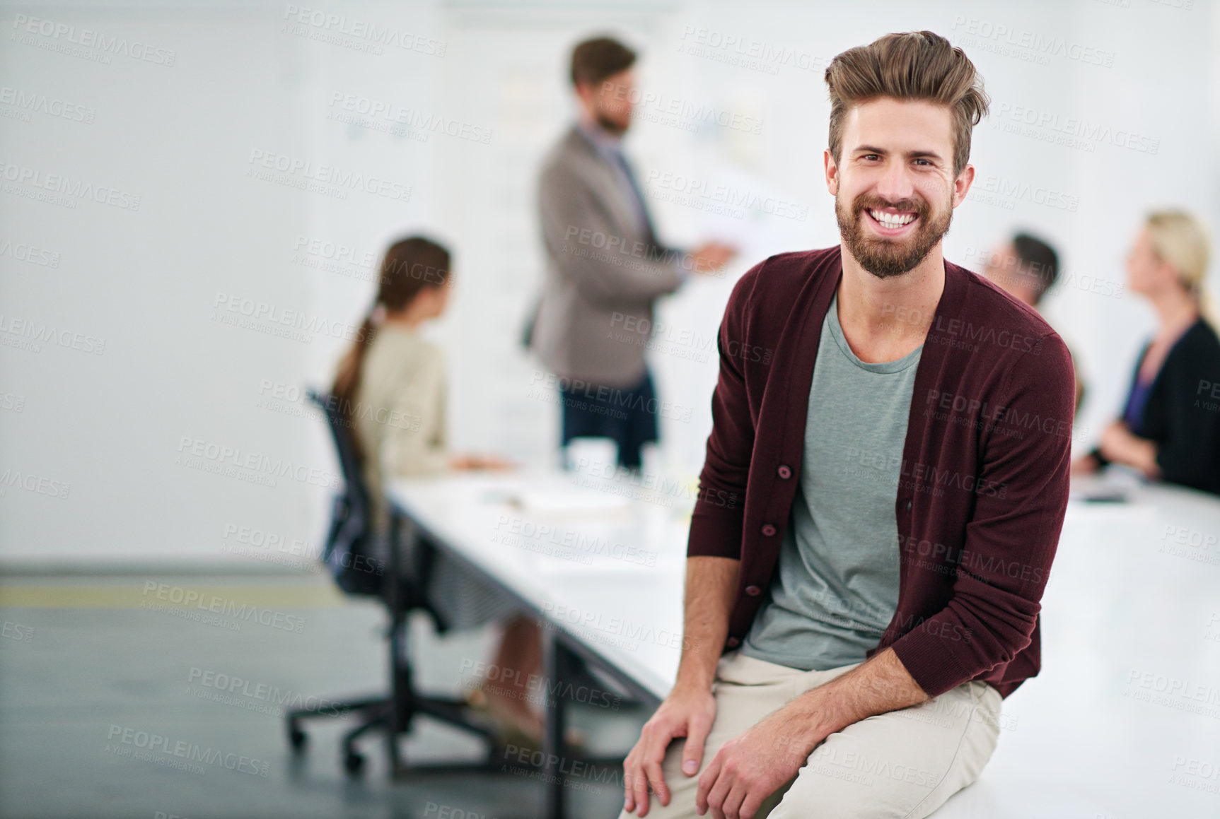 Buy stock photo Portrait of a young businessman in an office with colleagues in the background