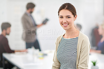 Buy stock photo Portrait of a young businesswoman in an office with colleagues in the background